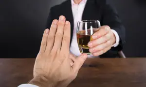 Dłoń odrzuca kieliszek z wódką, świadomie unikając pustych kalorii.
