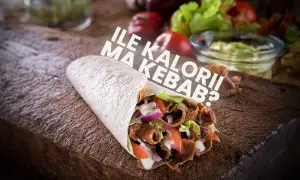 Pyszny kebab z warzywami i sosem na desce. Czy kebab jest zdrowy? Zależy od składników i sposobu przygotowania.