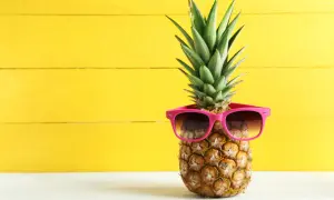 Ananas w okularach przeciwsłonecznych na żółtym tle. Poznaj jego niezwykłe ananas właściwości!