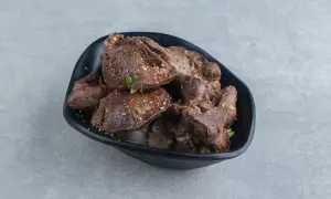 Porcja wątróbki drobiowej, przyprawionej i usmażonej, z widocznymi kawałkami cebuli. Idealna dla dbających o wątróbka drobiowa kcal.