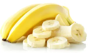 Kilka żółtych bananów, jeden obrany i pokrojony w plasterki, idealny na zatrucie pokarmowe.