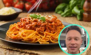 Pyszne spaghetti bolognese na talerzu, a obok uśmiechnięty mężczyzna. Zastanawiasz się, ile kcal ma spaghetti bolognese?