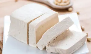 Kawałek pokrojonego tofu na talerzyku. Czy tofu jest zdrowe? To pytanie zadaje sobie wiele osób, szukając zdrowych alternatyw.