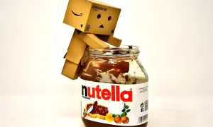 Mały robot Danbo siedzi na słoiku Nutelli, zastanawiając się nad jej kcal.
