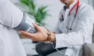 Lekarz mierzy ciśnienie pacjentowi, co jest kluczowe w diagnostyce i leczeniu, jak obniżyć wysokie ciśnienie rozkurczowe.
