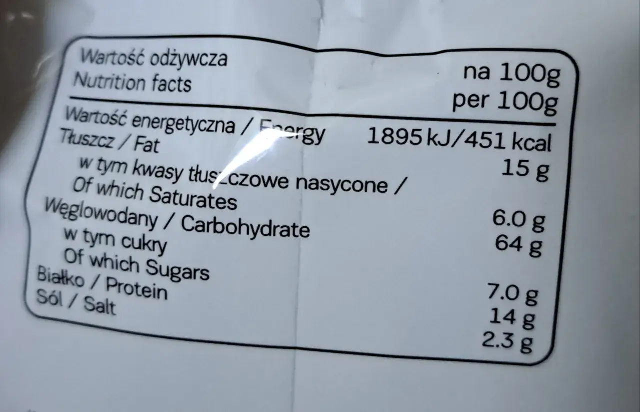 Etykieta z wartościami odżywczymi: 451 kcal na 100g. Tłuszcz 15g, węglowodany 64g, białko 7g. Idealne na 7days kcal.