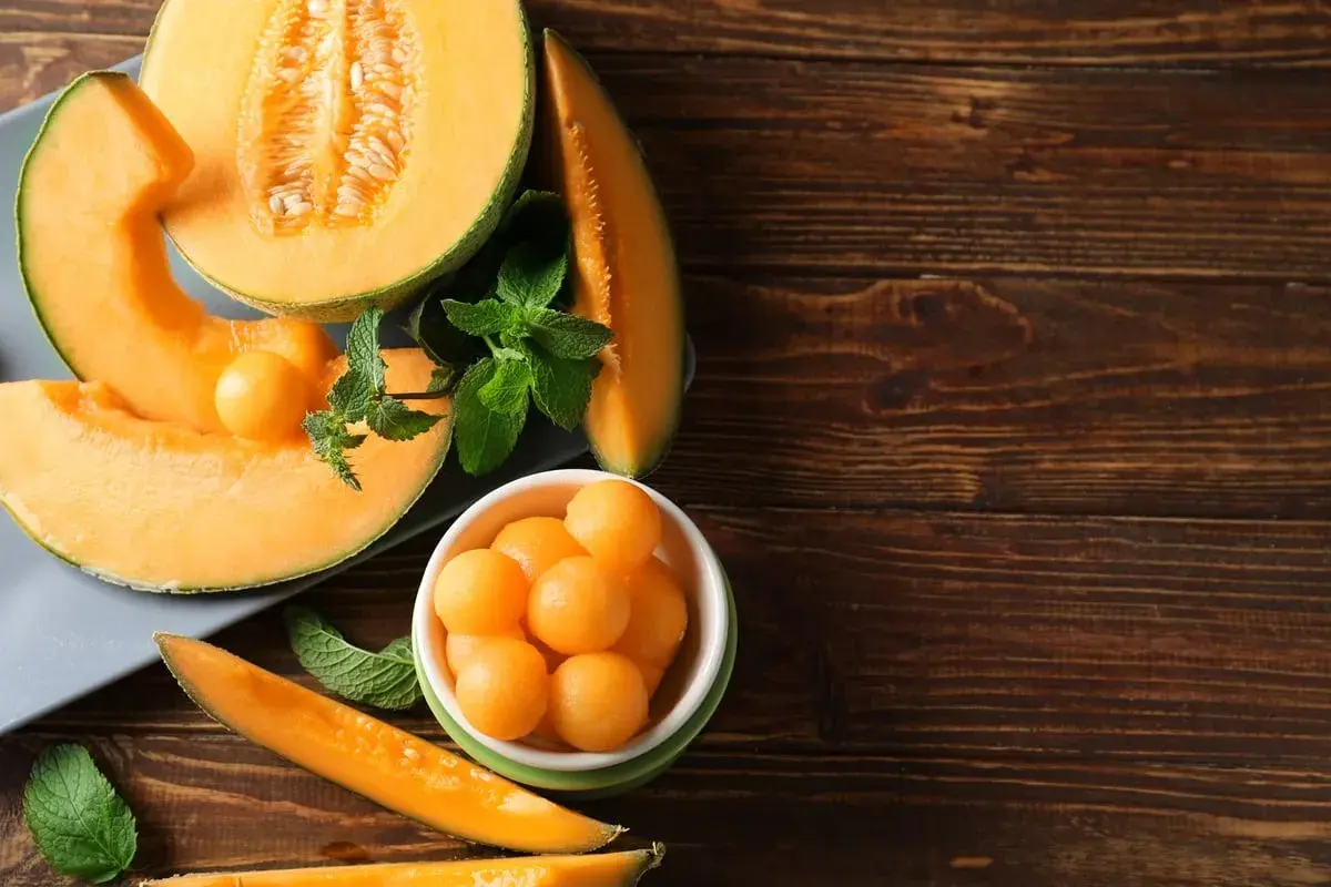 Soczysty melon, pokrojony w plastry i kulki, z listkami mięty. Idealna przekąska, niskie melon kcal.