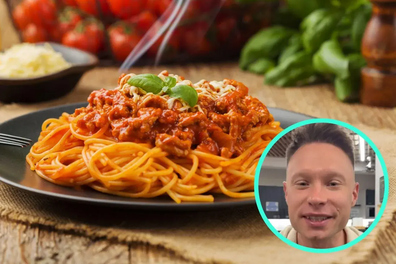 Pyszne spaghetti bolognese na talerzu, a obok uśmiechnięty mężczyzna. Zastanawiasz się, ile kcal ma spaghetti bolognese?