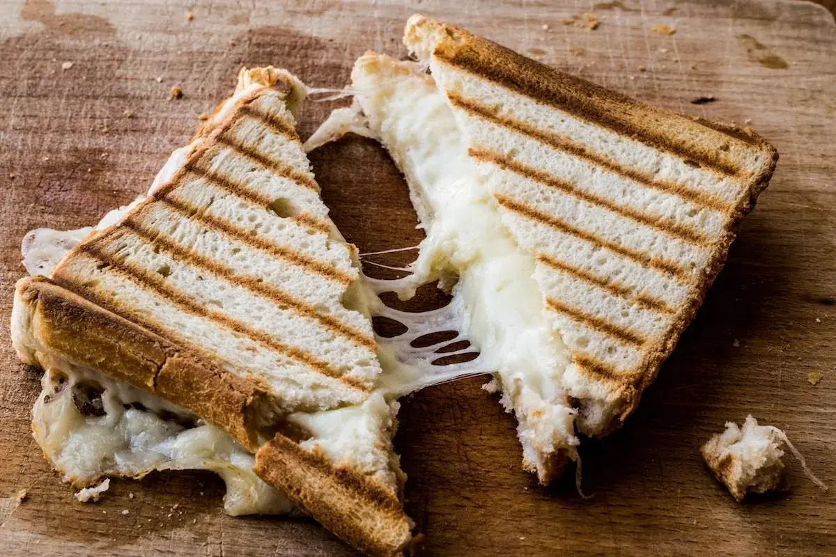 Pyszny tost z szynką i serem, ciągnący się jak biedronka. Idealny na szybki posiłek, zbilansowany pod względem kcal.