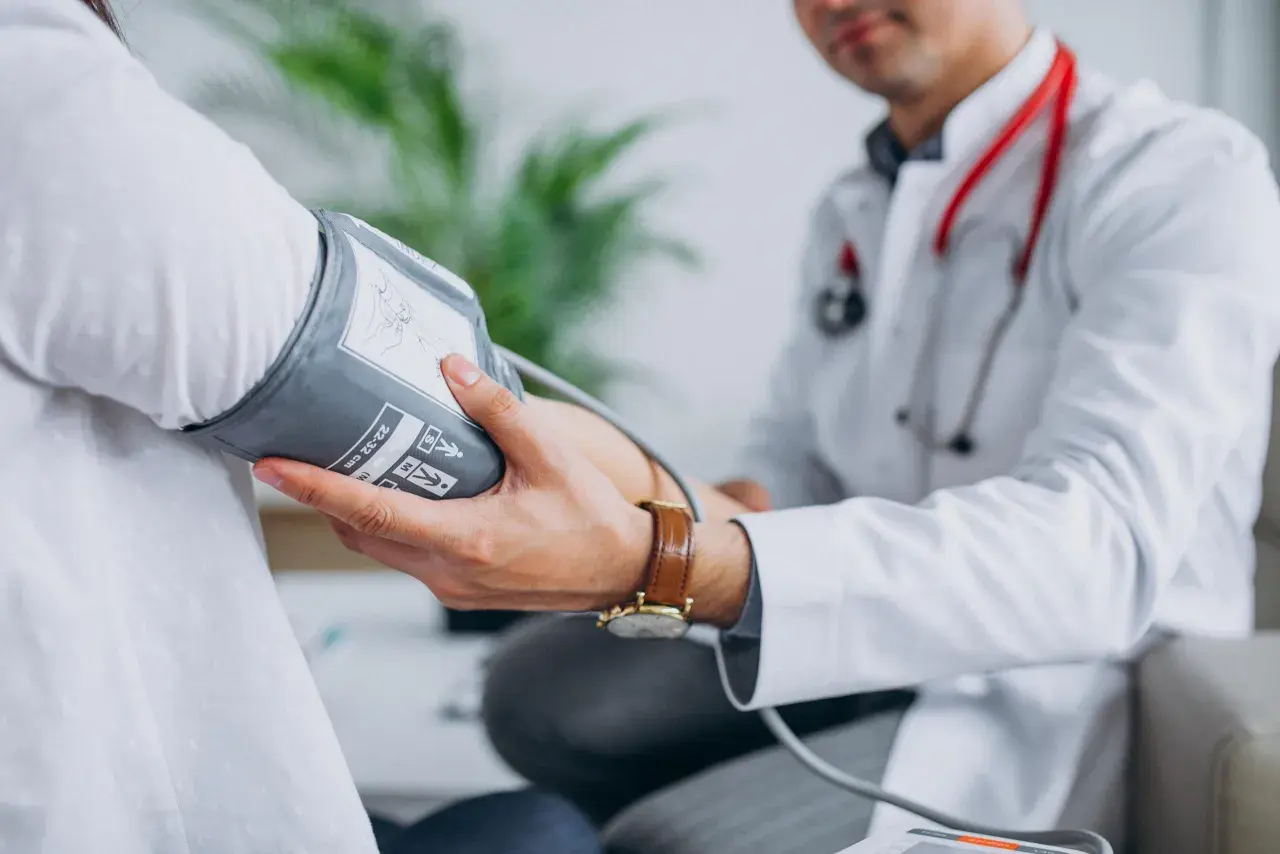Lekarz mierzy ciśnienie pacjentowi, co jest kluczowe w diagnostyce i leczeniu, jak obniżyć wysokie ciśnienie rozkurczowe.