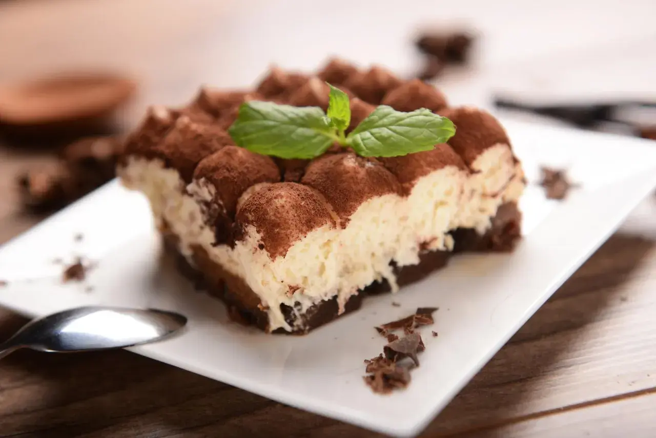 Pyszne tiramisu, posypane kakao i udekorowane miętą. Idealne na deser, choć warto pamiętać o jego tiramisu kcal.