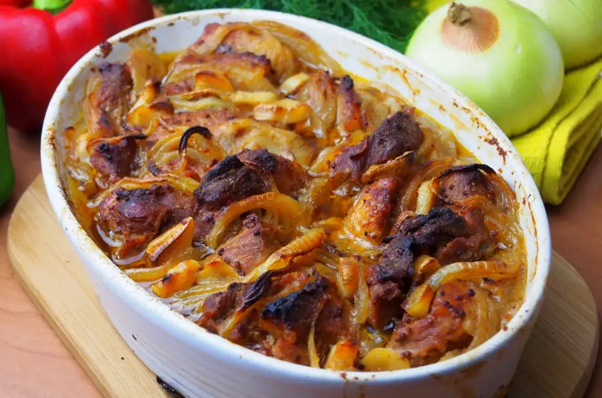 Pieczona łopatka wieprzowa z cebulą w naczyniu żaroodpornym. Pyszne danie, które warto znać, jeśli interesuje Cię łopatka wieprzowa kcal.