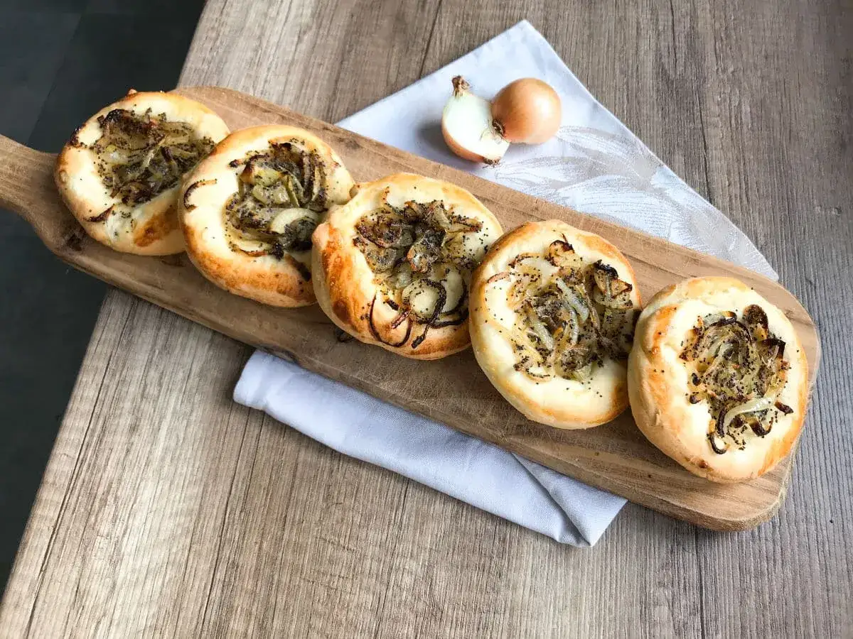 Pięć cebularzy z makiem na desce. Zastanawiasz się nad cebularz Lidl kcal? Idealne na przekąskę!