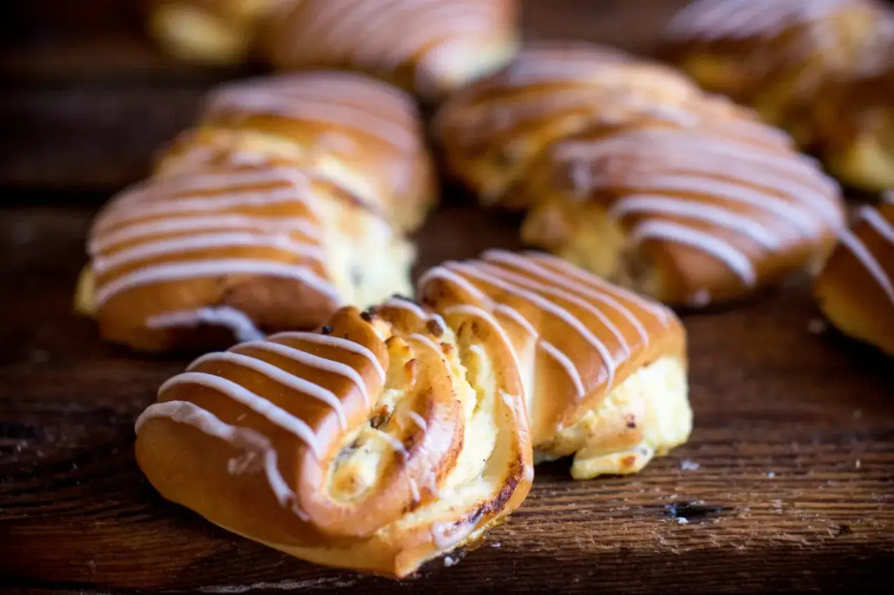 Słodka drożdżówka z serem, polana lukrem. Idealna na przekąskę, choć warto sprawdzić jej drożdżówka z serem kcal.