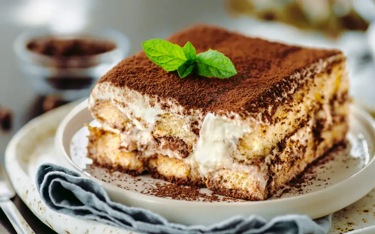 Pyszne tiramisu, posypane kakao i udekorowane miętą. Idealne na deser, choć warto pamiętać o jego tiramisu kcal.